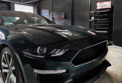 Czarny Ford Mustang Bullit w warsztacie, przygotowany do wygłuszenia materiałami Bitmat