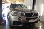 Szare BMW X5 zaparkowane w warsztacie, przygotowane do kompleksowego wygłuszania materiałami Bitmat