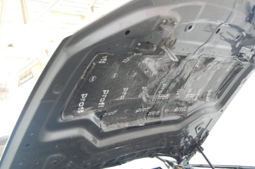 Wewnętrzna część otwartej maski silnika w BMW X5 dokładnie oklejona matą alubutylową Bitmat