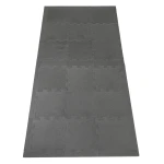 Rozłożona duża powierzchnia ochronna wykonana z połączonych, szarych mat piankowych typu puzzle.