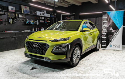 Limonkowa Hyundai Kona w warsztacie przygotowana do pełnego procesu wyciszenia dachu podłogi i bagażnika materiałami Bitmat