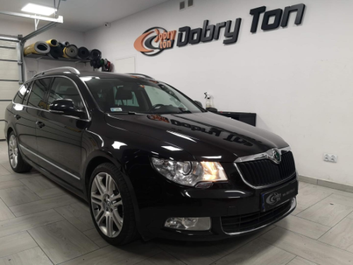 Czarna Skoda Superb w warsztacie, przygotowana do profesjonalnego wygłuszenia drzwi materiałami Bitmat