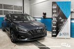 Ciemny Hyundai i30 w warsztacie przygotowany do profesjonalnego wyciszenia maski i podszybia materiałami Bitmat