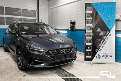 Ciemny Hyundai i30 w warsztacie przygotowany do profesjonalnego wyciszenia maski i podszybia materiałami Bitmat