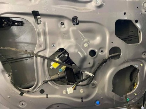 Zdemontowany boczek i odsłonięta wewnętrzna blacha drzwi w Chevrolecie Aveo przed nałożeniem wygłuszenia Bitmat