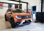 Pomarańczowa Dacia Duster w warsztacie, przygotowana do kompleksowego wygłuszania materiałami Bitmat