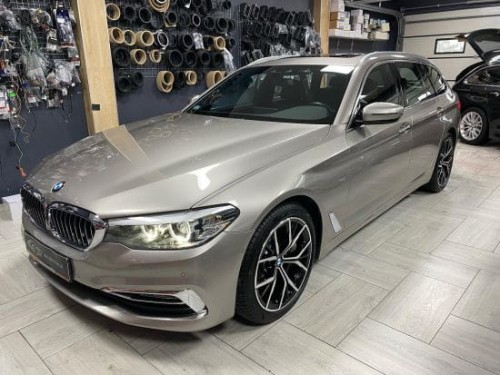 Srebrne BMW 530D zaparkowane w jasnym warsztacie, przygotowane do wygłuszania drzwi i bagażnika materiałami Bitmat